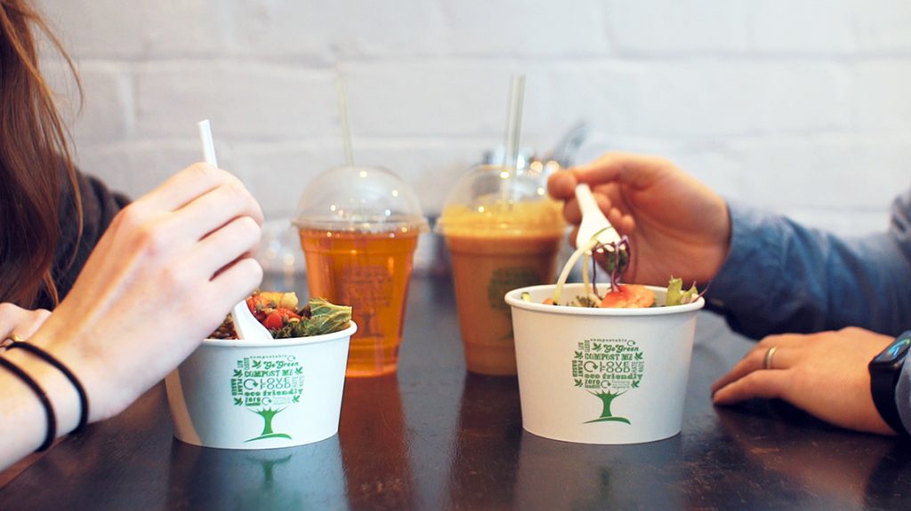 Two people enjoying lunch from Vegware plant-based foodservice disposables